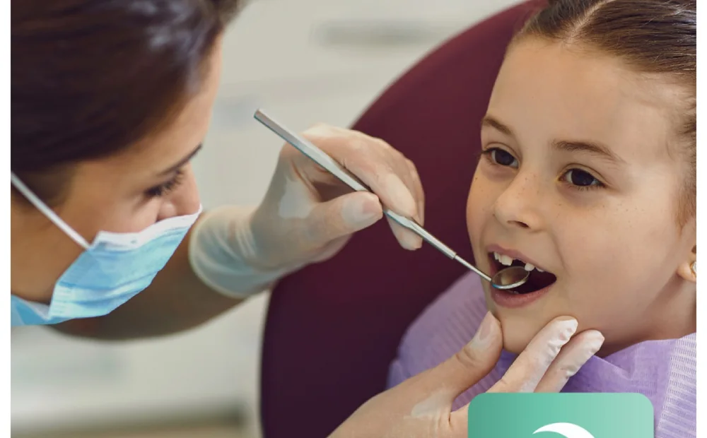 A dentist examining a young patient's teeth