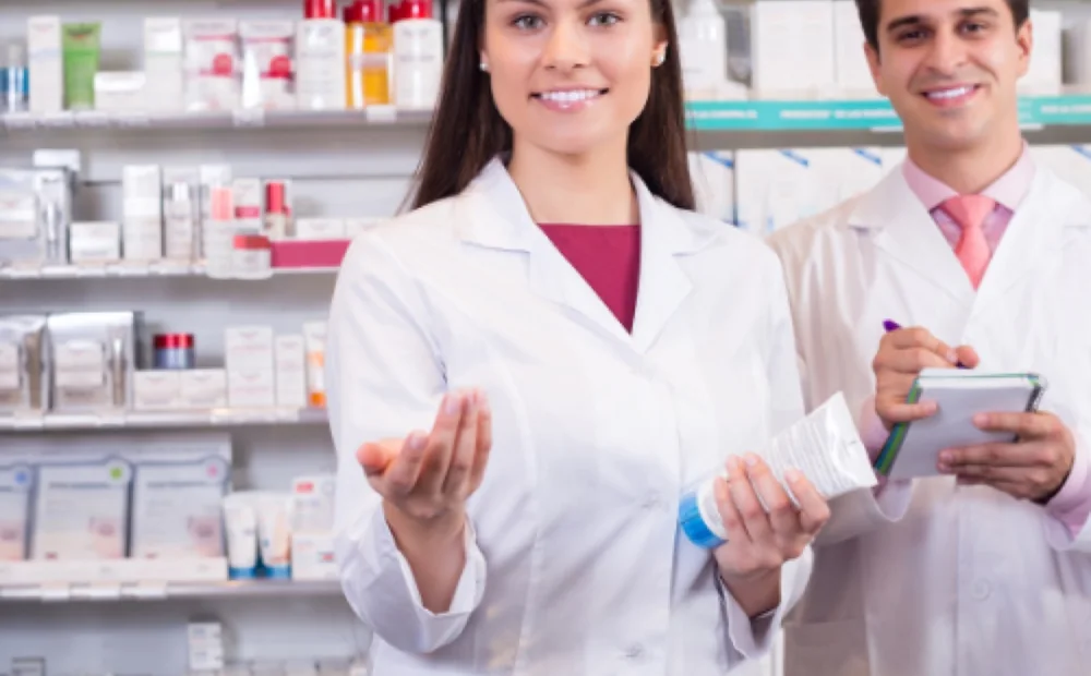 Two pharmacists behind the counter of a community pharmacy