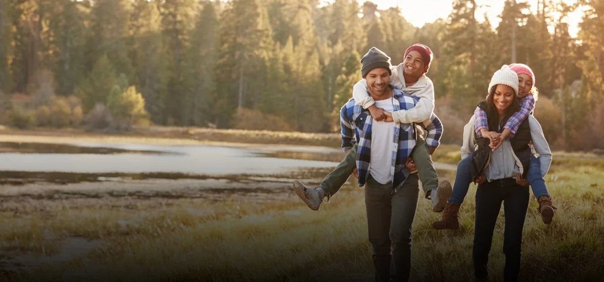 A family walking together beside a Montana lake in autumn